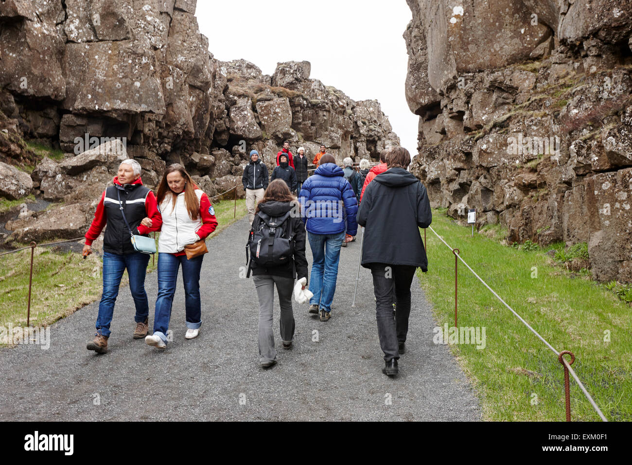 I turisti a piedi attraverso il Almannagja linea anomalia nel mid-atlantic ridge Nord America placca Thingvellir parco nazionale di Islanda Foto Stock