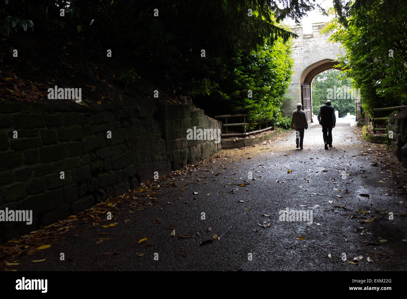 Coppia di anziani camminare lungo un corridoio scuro Foto Stock