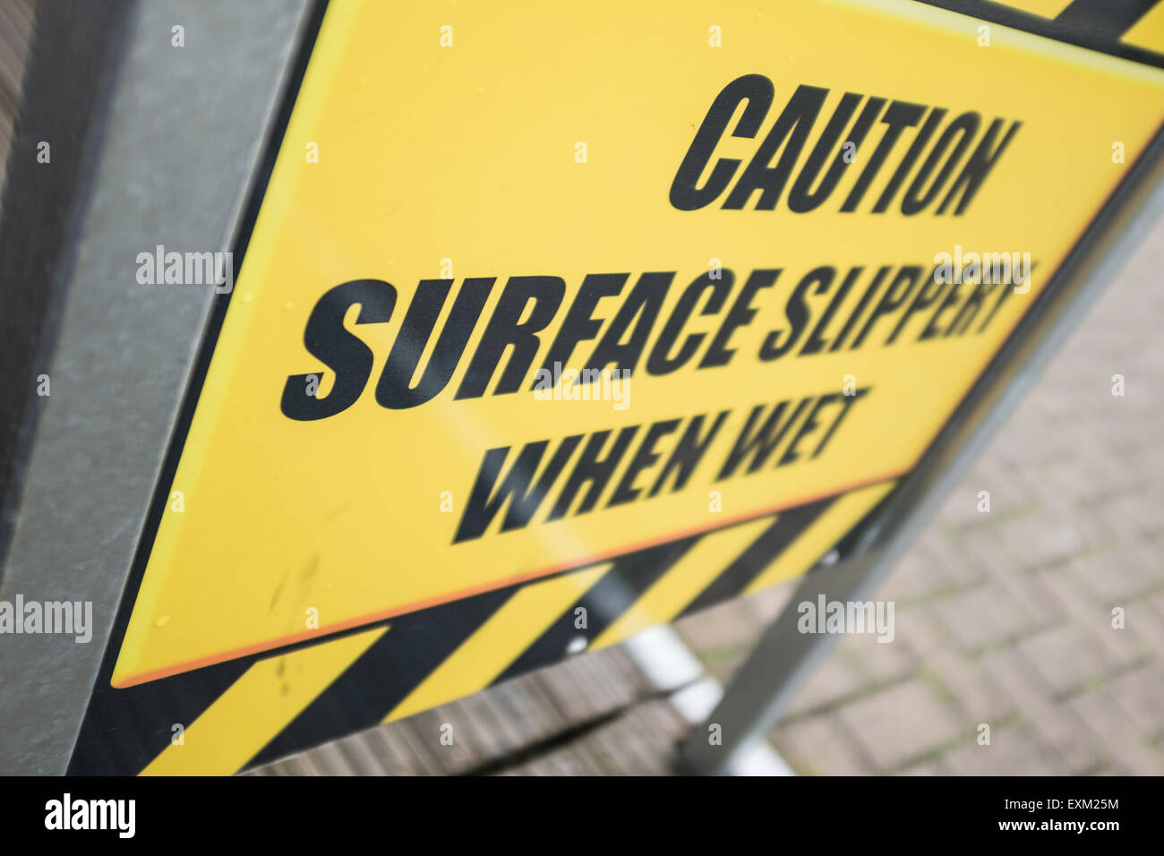 Attenzione superficie scivoloso quando è bagnato, cartello giallo Foto Stock