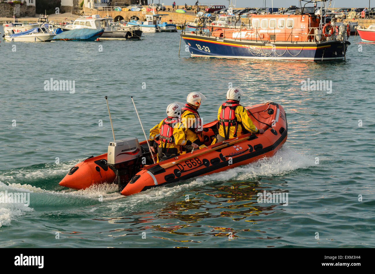 RNLI scialuppa di salvataggio costiera passando la scialuppa di salvataggio Offshore nel porto, St Ives, Cornwall, England, Regno Unito Foto Stock