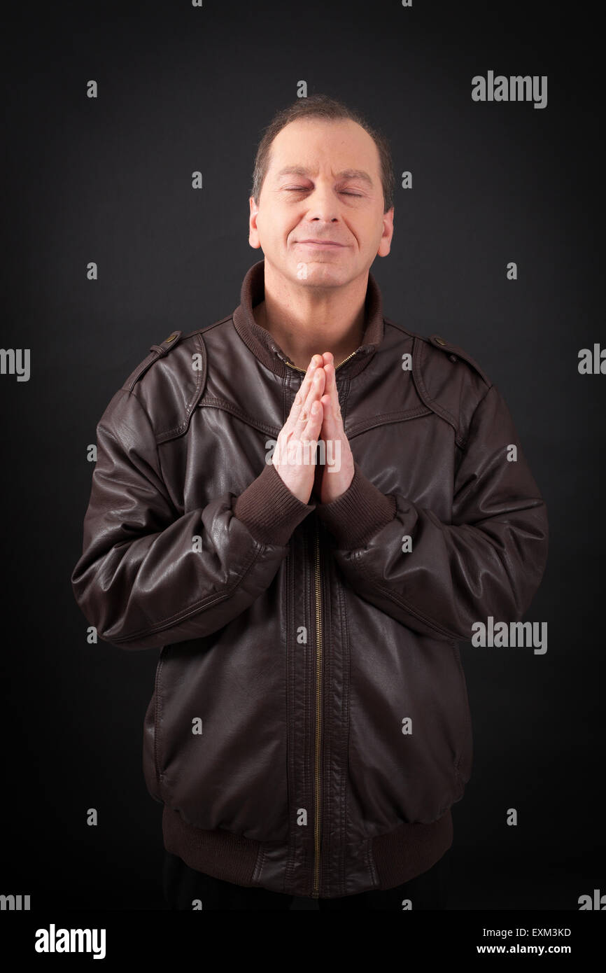 Uomo bello fare espressioni diverse in diversi set di vestiti: la preghiera Foto Stock