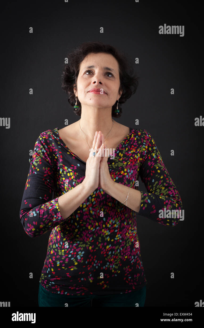Bella donna facendo espressioni diverse in diversi set di vestiti: la preghiera Foto Stock