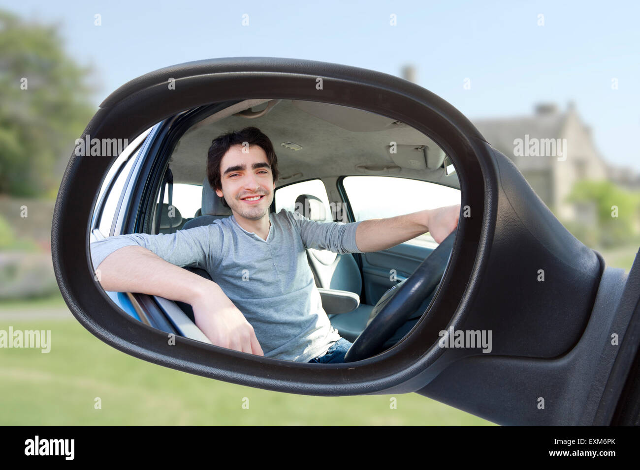 Vista attraverso lo specchietto retrovisore di un attraente l uomo nella sua auto Foto Stock