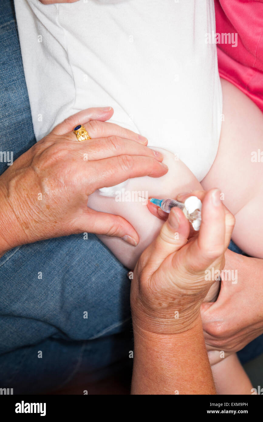 MMR immunizzazione etc / inoculazione / jab / da una siringa in un anno di età / 12 13 dodici tredici mese del bambino / coscia della gamba. Foto Stock