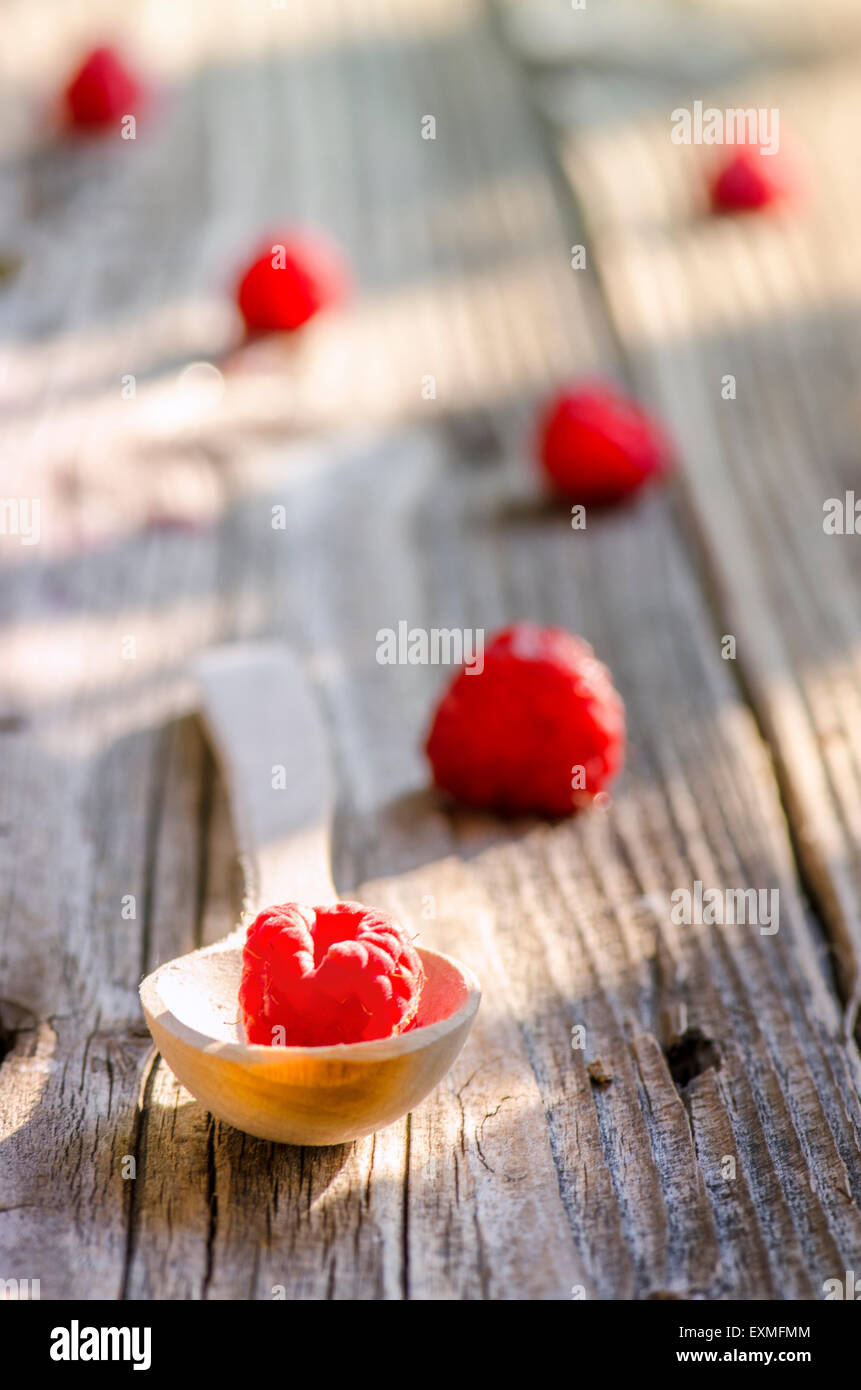 Rasberry in cucchiaio di legno isolato su vintage sfondo di legno Foto Stock