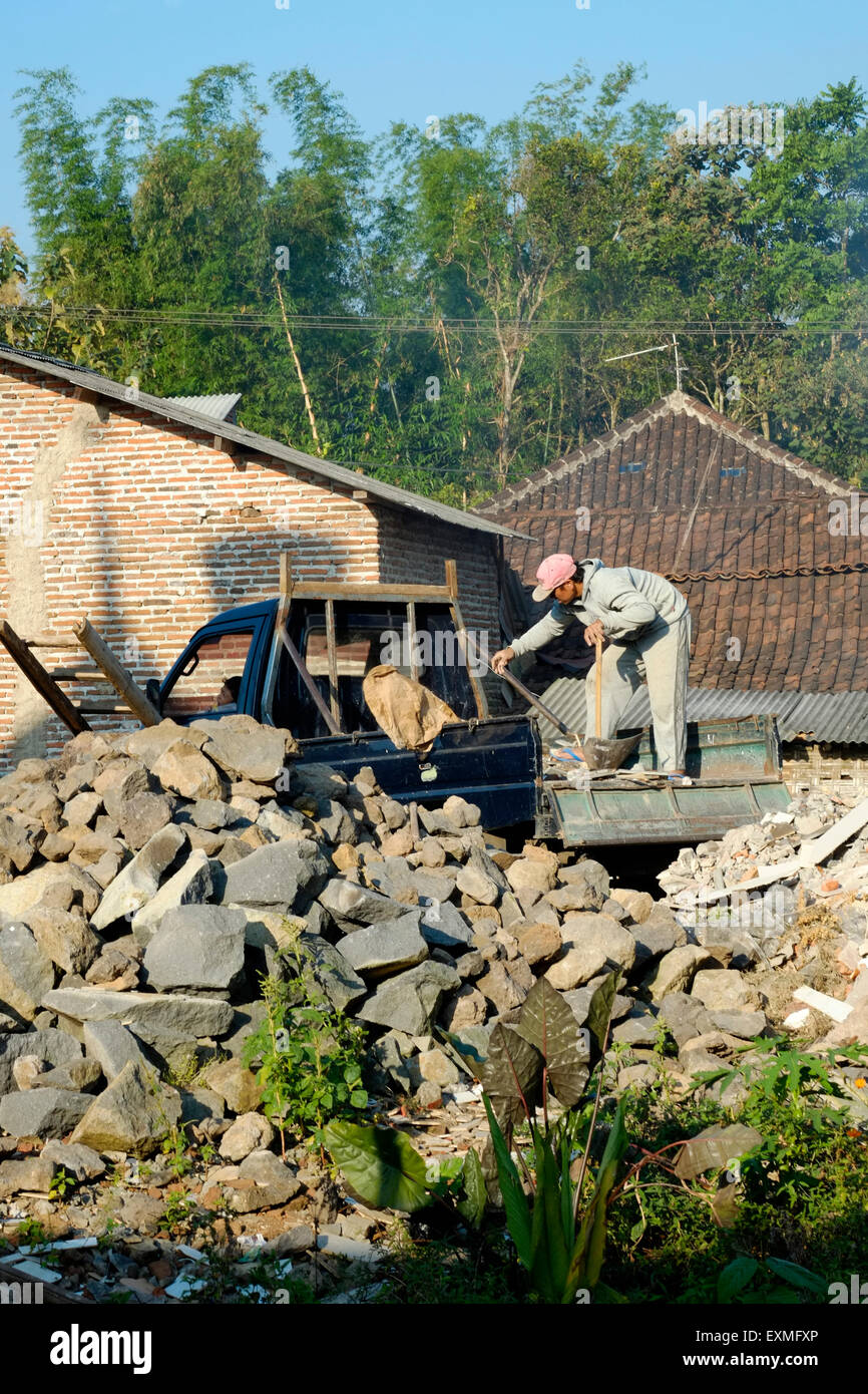 Lavoratori locali dump macerie dal retro di un camion sulla massa di rifiuti in un piccolo villaggio in java indonesia Foto Stock