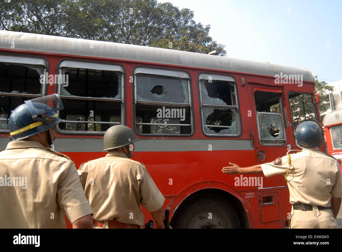 Il personale di polizia di guardia bus migliore con il vetro in frantumi dopo la comunità Dalit resort di proteste violente Mumbai Foto Stock
