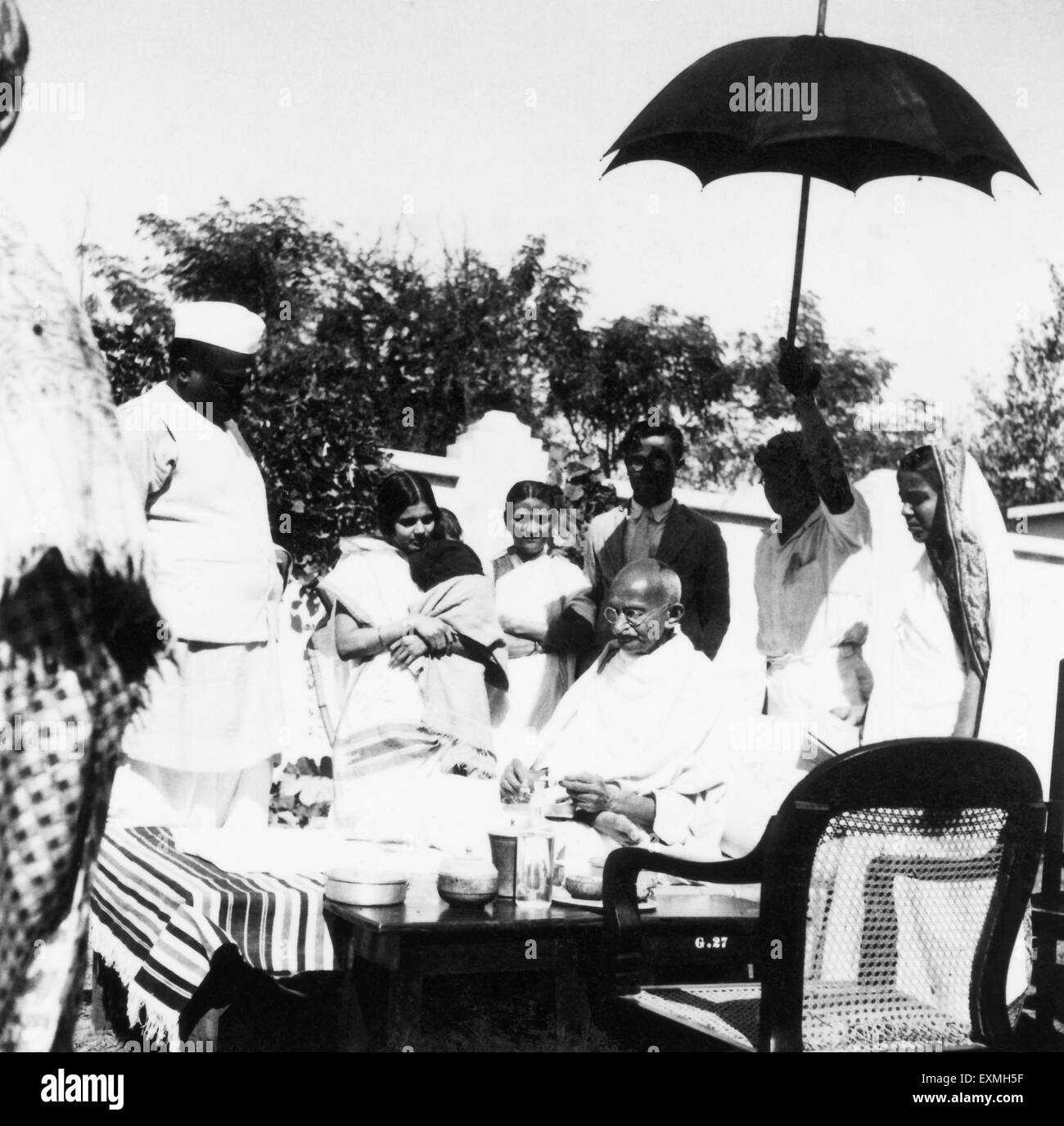 Il Mahatma Gandhi ; seduto su un tavolo ; circondato da gente ; 1941 ; India n. MR Foto Stock