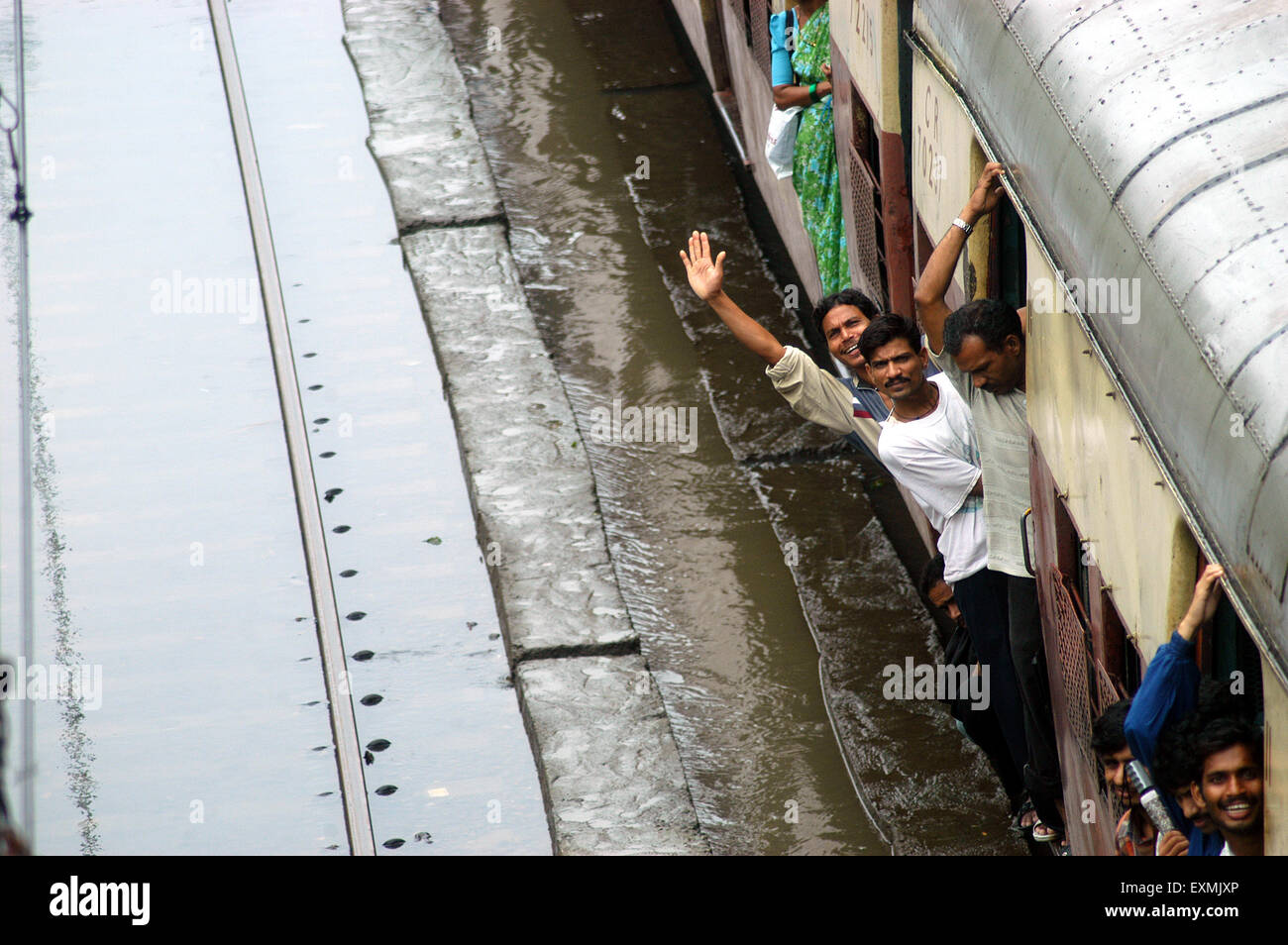 Treno locale passano attraverso inondati di binari ferroviari causati a causa di forte pioggia a Bombay Mumbai; Maharashtra, India Foto Stock