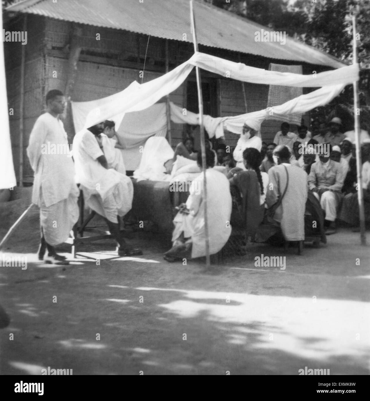 Il Mahatma Gandhi parlando di persone mentre facendo bagni di sole villaggio Noakhali Dasgharia Bengala Orientale Kanu Gandhi alloggiato Novembre 1946 Foto Stock