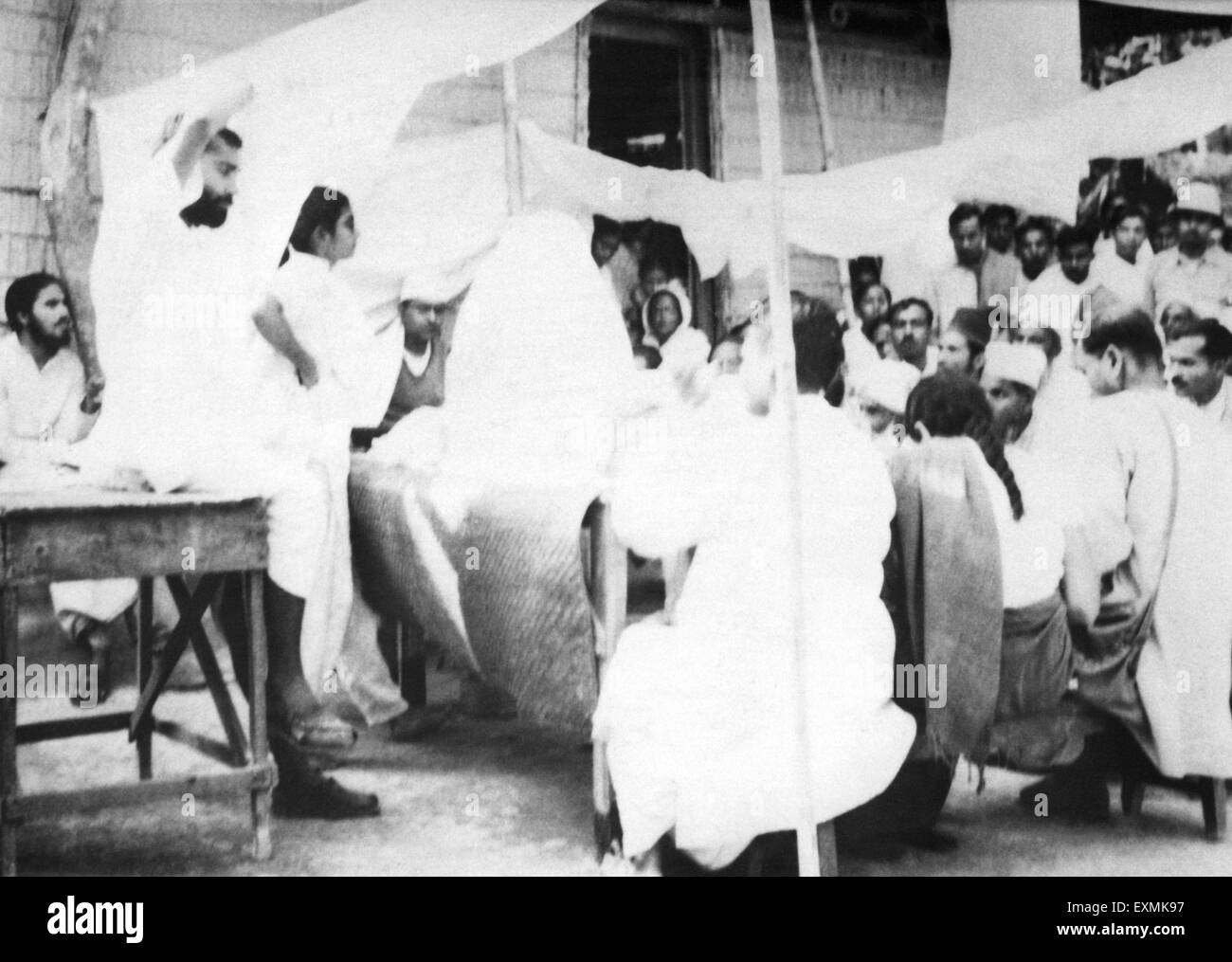 Il Mahatma Gandhi ; a parlare con la gente mentre prendendo il sole presso il village Dasgharia Noakhali Bengala Orientale dove Kanu Gandhi alloggiato Foto Stock