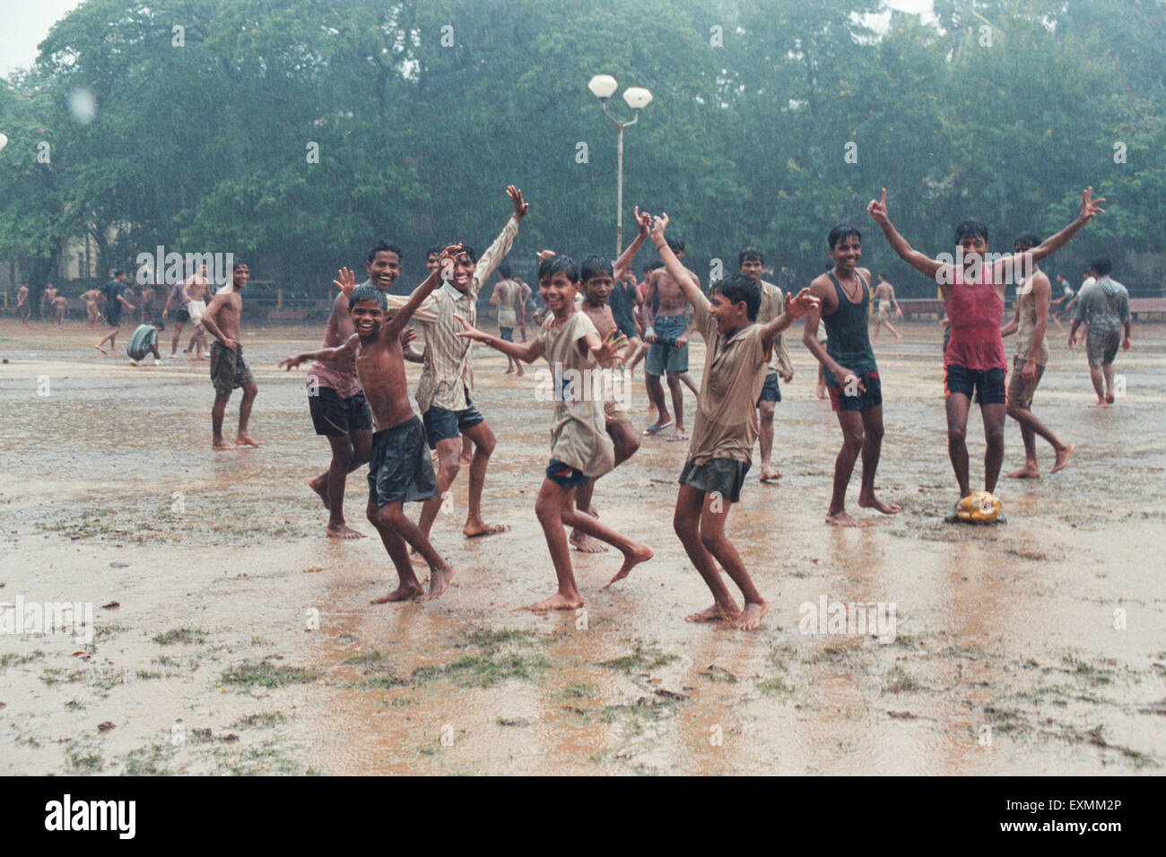I bambini che giocano a calcio in piogge monsoniche Azad Maidan Mumbai India Foto Stock