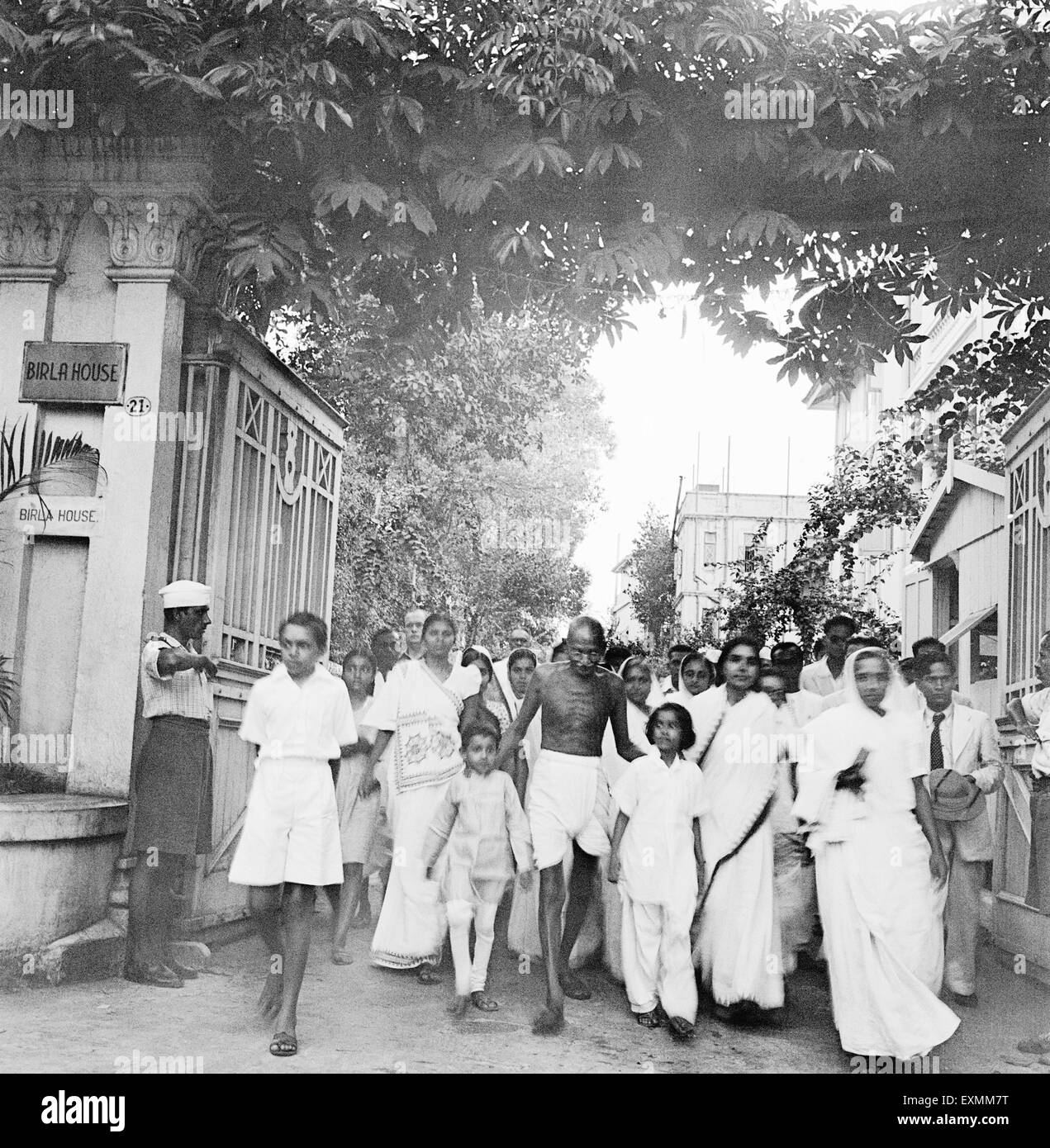 Il Mahatma Gandhi ; accompagnato da altri ; il suo modo per un incontro di preghiera da Birla casa per casa Rungta ; Mumbai Foto Stock
