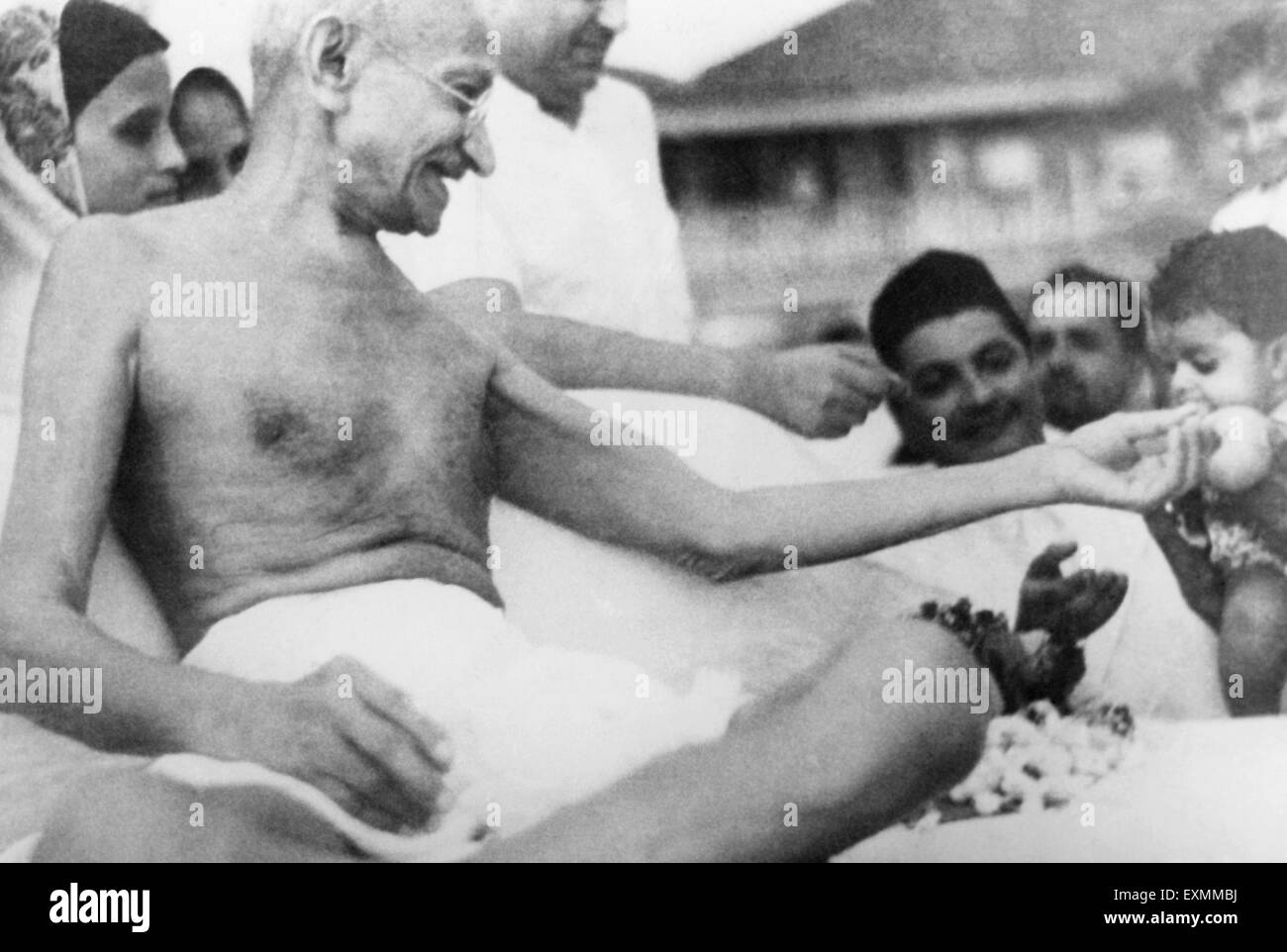 Il Mahatma Gandhi ; distribuzione di frutta per bambini in spiaggia Juhu Mumbai India May 1944 Foto Stock
