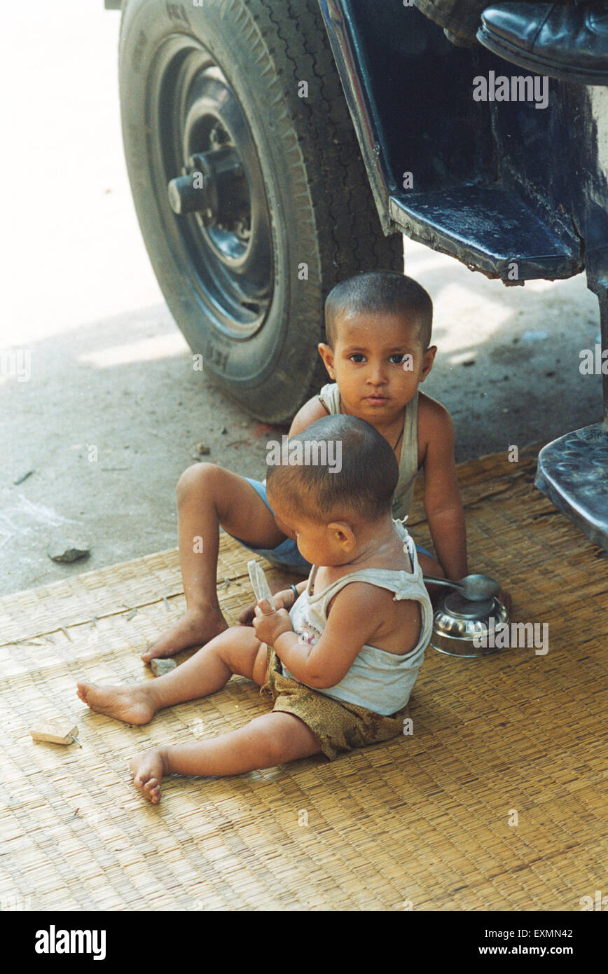 Bambini neonati seduti sotto la polizia jeep bombay mumbai Maharashtra india asia Foto Stock