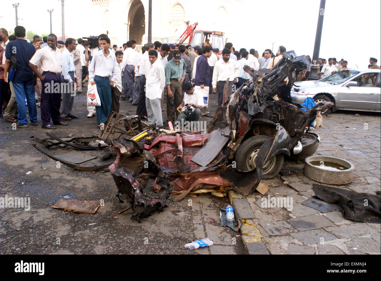 Persone ispezione auto danneggiato bomba blast explosion Gateway of India Mumbai Bombay Mumbai India Foto Stock