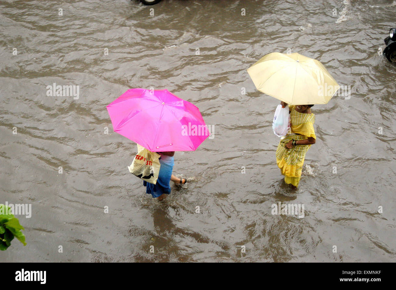 Le donne di strada allagata a piedi umbrellas monsoni piogge acqua Vidyavihar Bombay Mumbai India Foto Stock