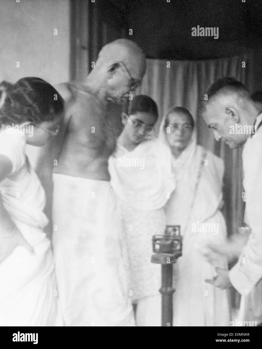 Il Mahatma Gandhi stando in piedi sulla scala di pesatura durante la sua Belia Ghat fast ; 1946 Abha Gandhi ; Manu Gandhi Sharad Bose Foto Stock