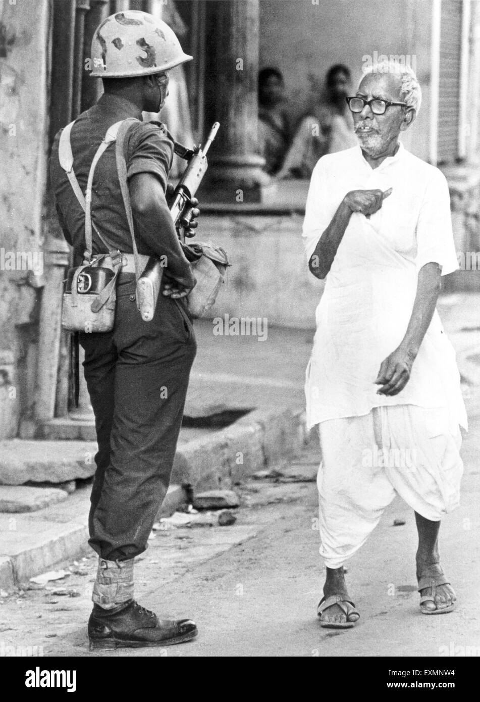 Il vecchio uomo ha paura del soldato dell'esercito con un fucile mumbai india Foto Stock