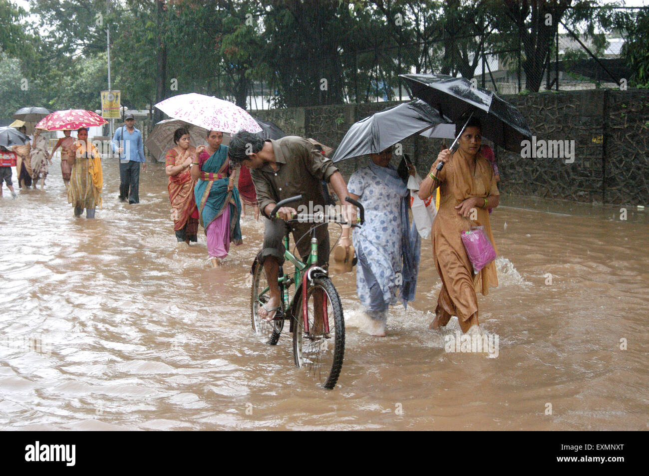 La gente a piedi piogge monsoniche acqua strade allagate Vidyavihar Mumbai India Maharashtra Foto Stock