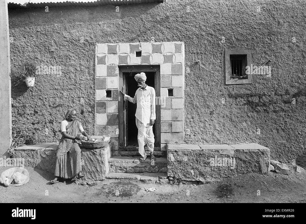 Uomo donna seduta al di fuori di casa Munagoli villaggio quartiere Bijapur Karnataka India Foto Stock