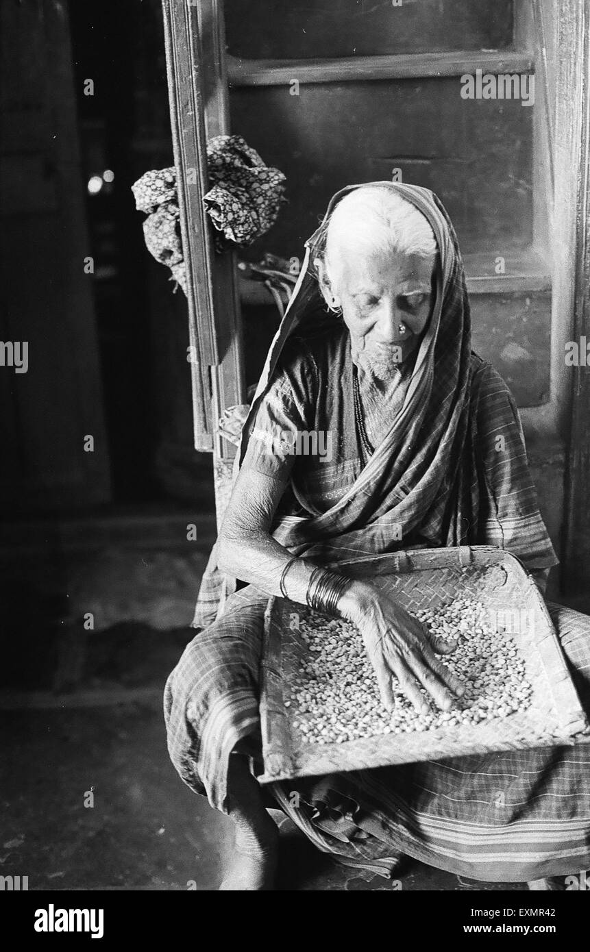 Donna vecchia granella di pulizia ; Lokur village ; Dharwar district ; Karnataka ; India Foto Stock