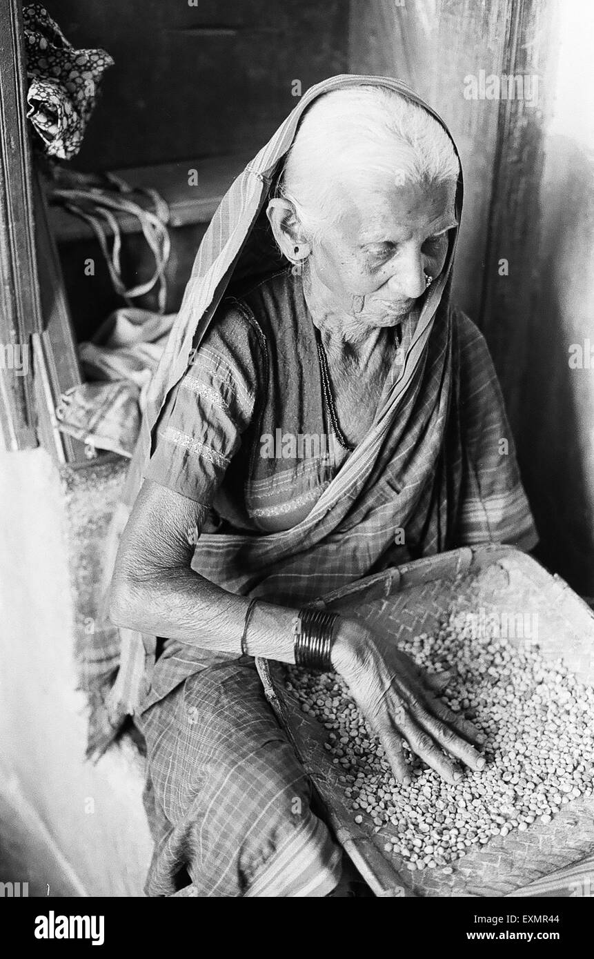 Il vecchio donna indiana la pulizia della granella villaggio Lokur Dharwar district Karnataka India Foto Stock