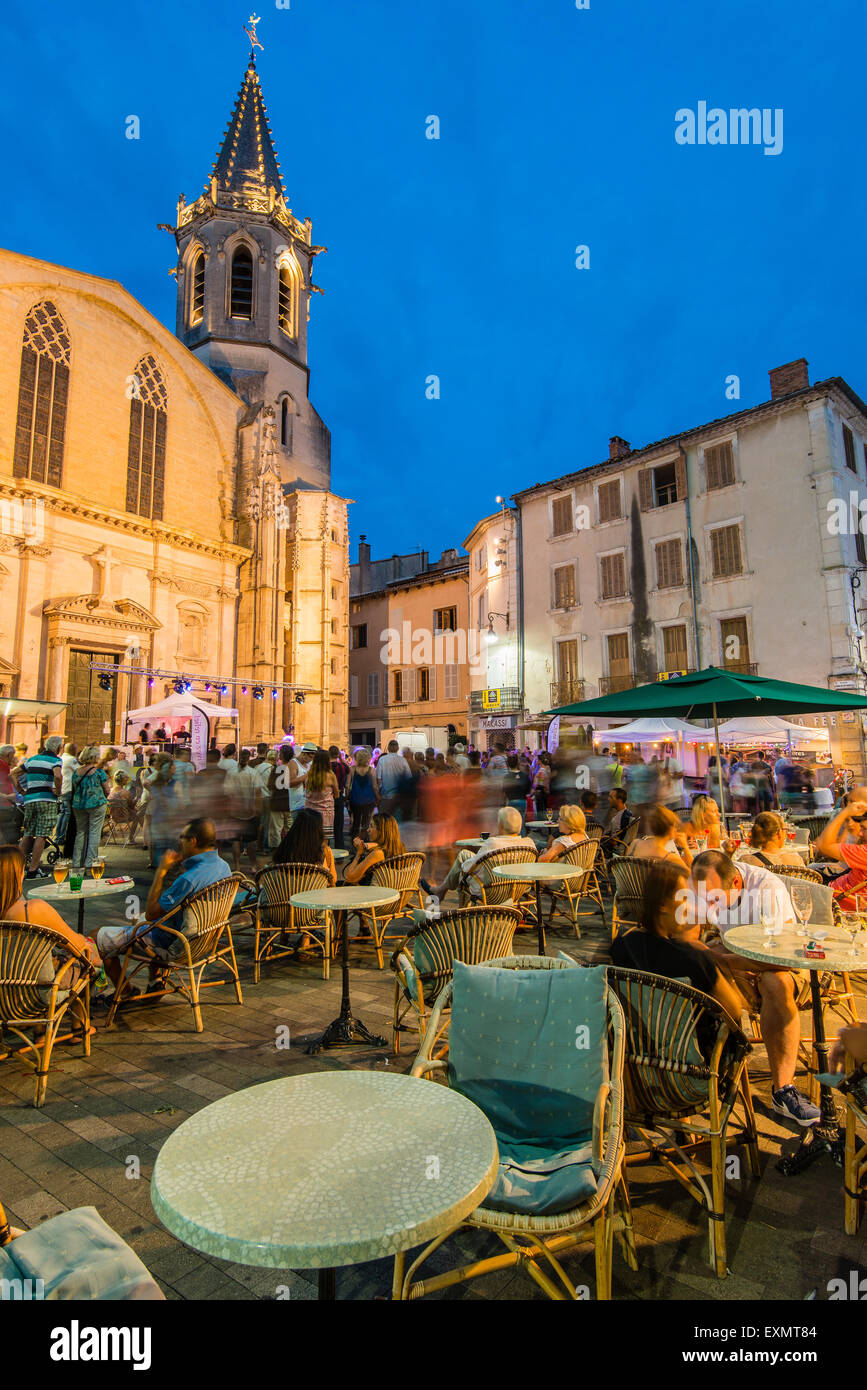 Vista notturna di piazza della cattedrale e outdoor Cafe con posti a sedere ai tavoli esterni, Carpentras, Provenza, Francia Foto Stock