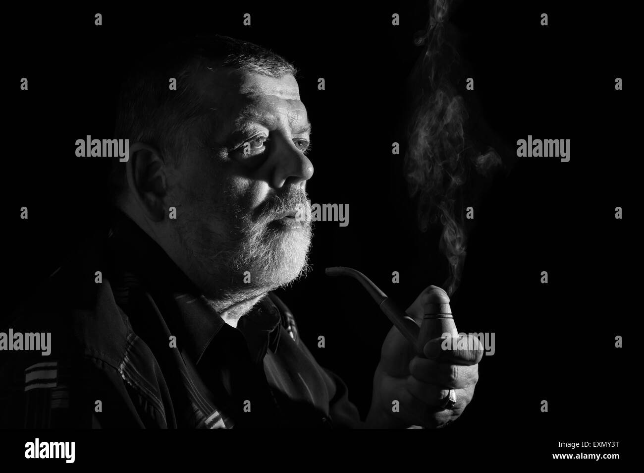Bianco e nero drammatico ritratto di senior di tabacco da fumo tubo Foto Stock