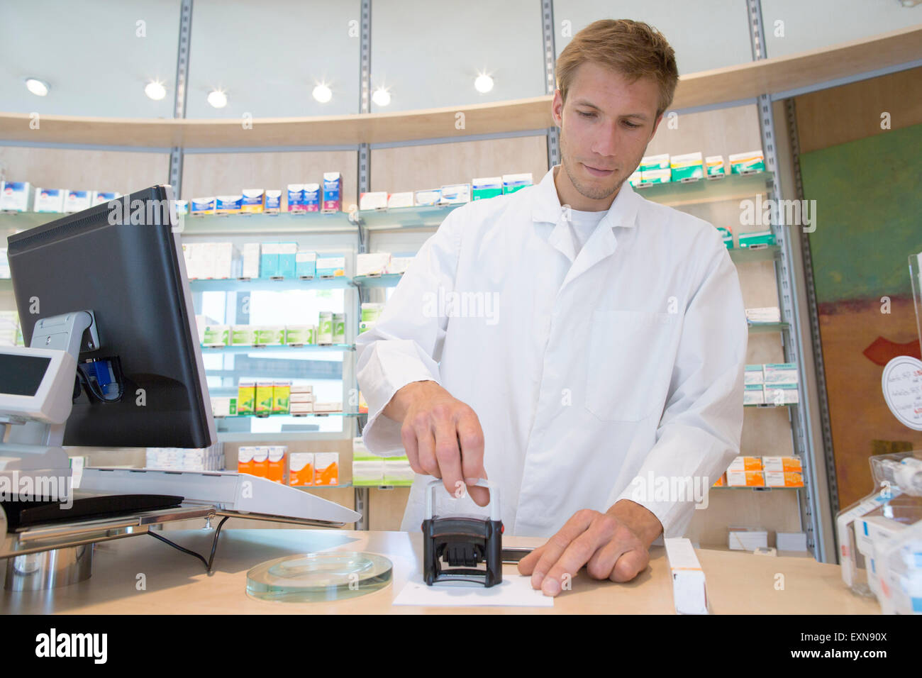 Giovane farmacista prescrizione di timbratura Foto Stock