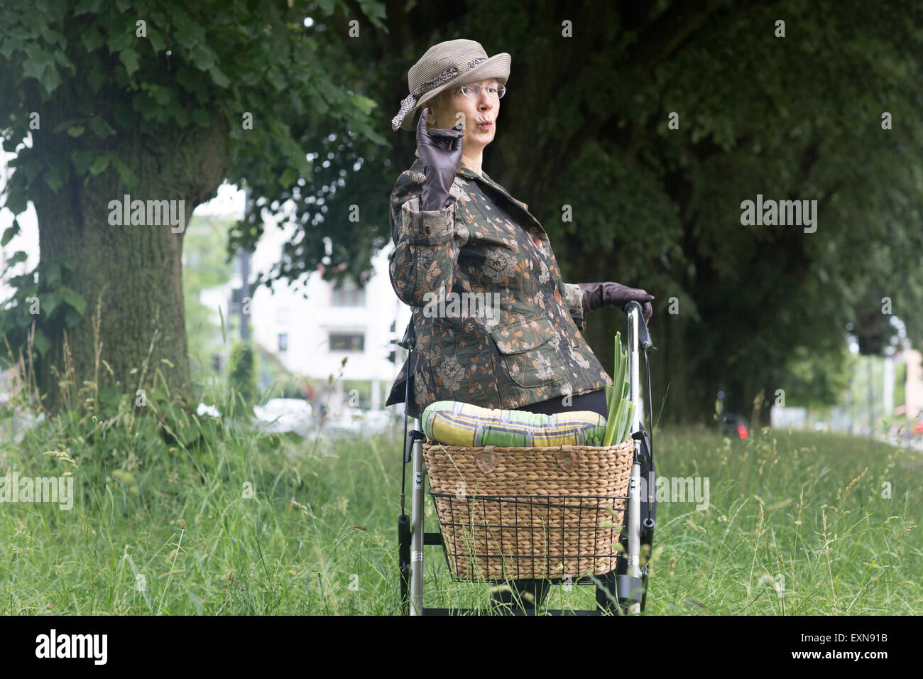 Senior donna con scuotipaglia con ruote aventi una pausa Foto Stock