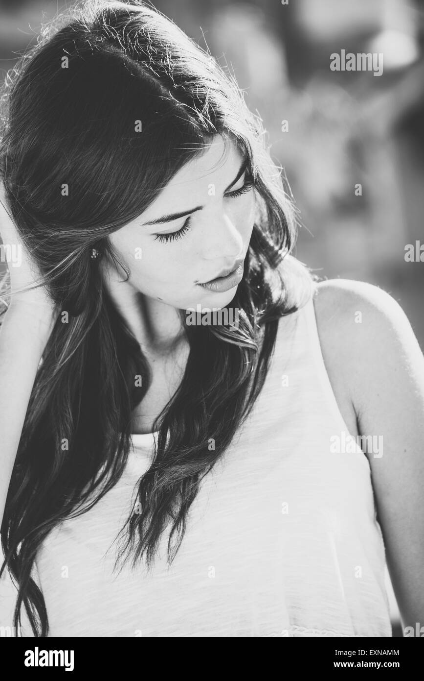 Seri con i capelli lunghi giovane donna all'aperto Foto Stock