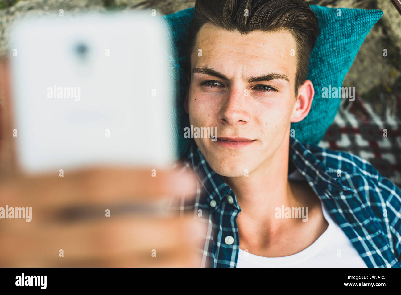 Giovane uomo all'aperto in possesso di un telefono cellulare Foto Stock