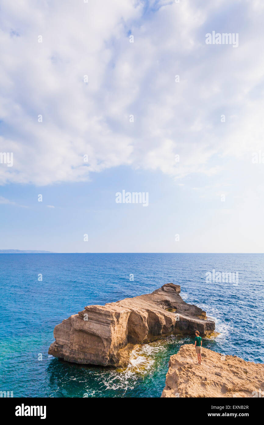 Grecia Isole dell' Egeo, Rodi, giovane uomo cercando di isola rocciosa Foto Stock