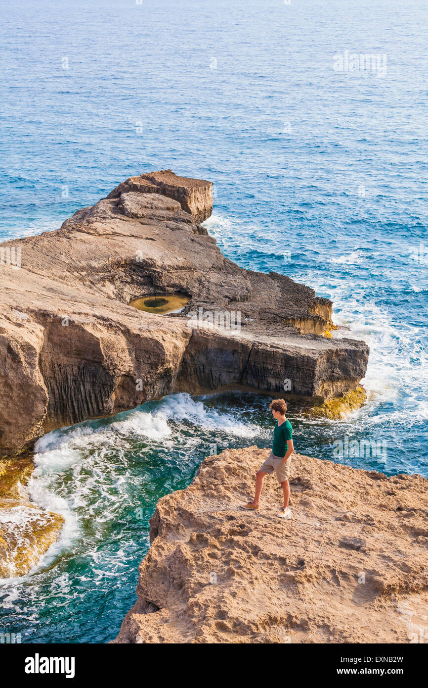 Grecia Isole dell' Egeo, Rodi, giovane uomo cercando di isola rocciosa Foto Stock