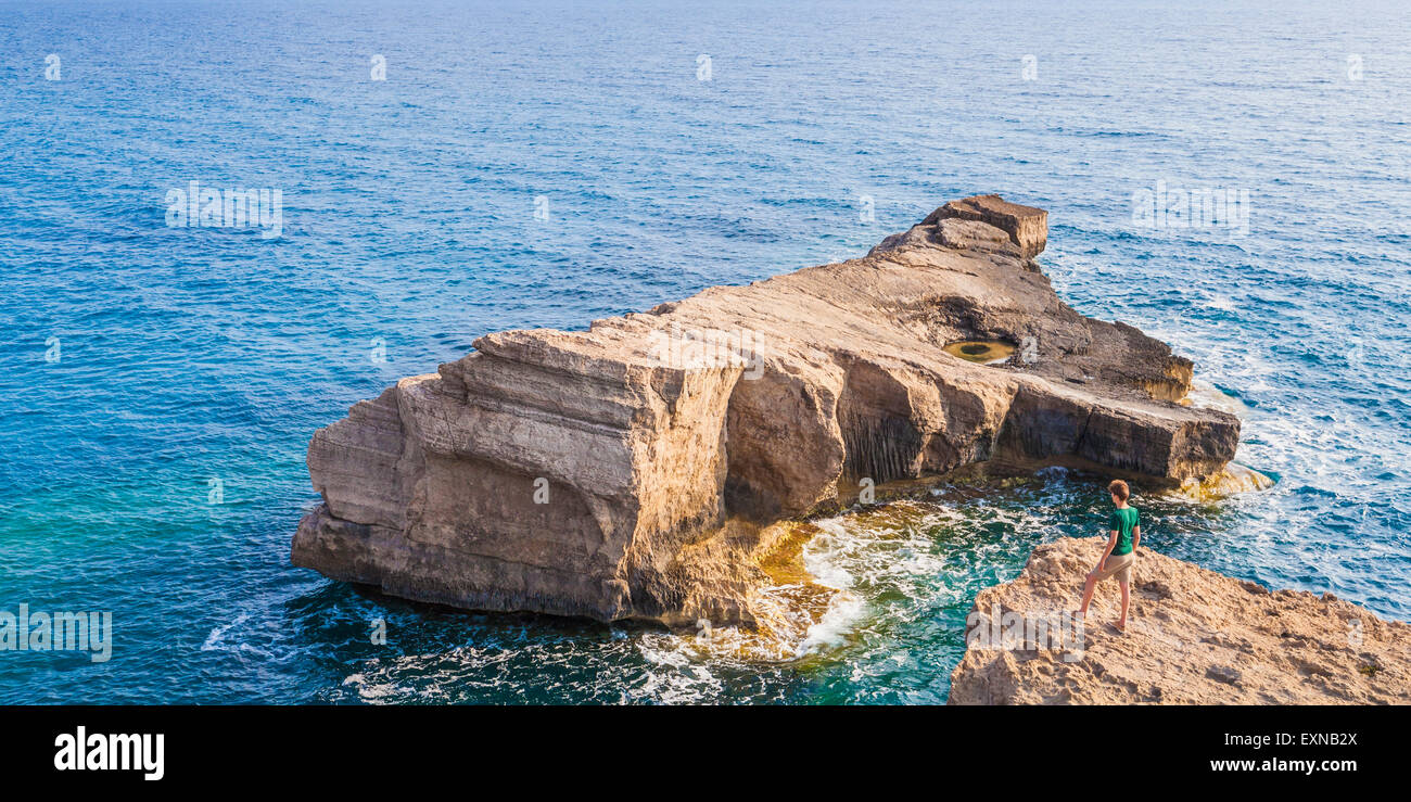 Grecia Isole dell' Egeo, Rodi, giovane uomo cercando di isola rocciosa Foto Stock