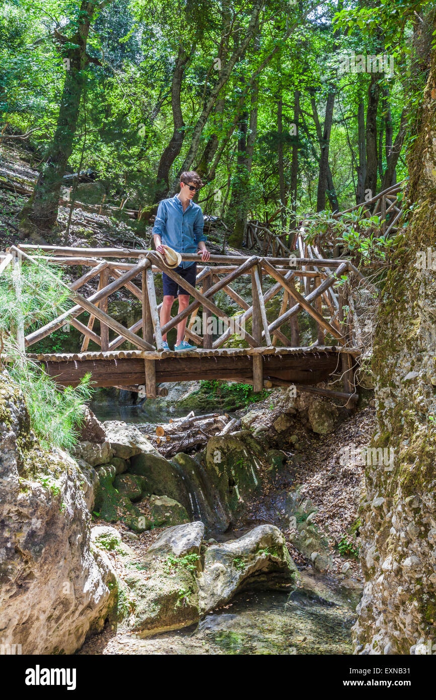 La Grecia, Rodi, giovane uomo in piedi sul ponte di legno in legno Foto Stock