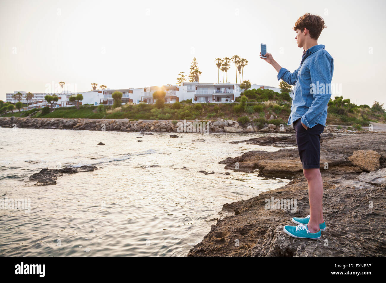 La Grecia, Rodi, giovane fotografare con lo smartphone sul lungomare Foto Stock
