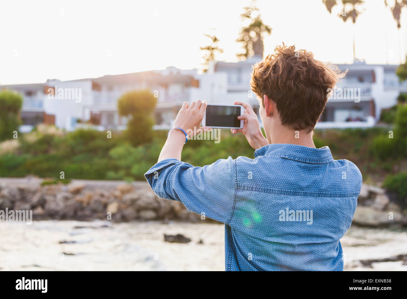 La Grecia, Rodi, giovane fotografare con lo smartphone sul lungomare Foto Stock