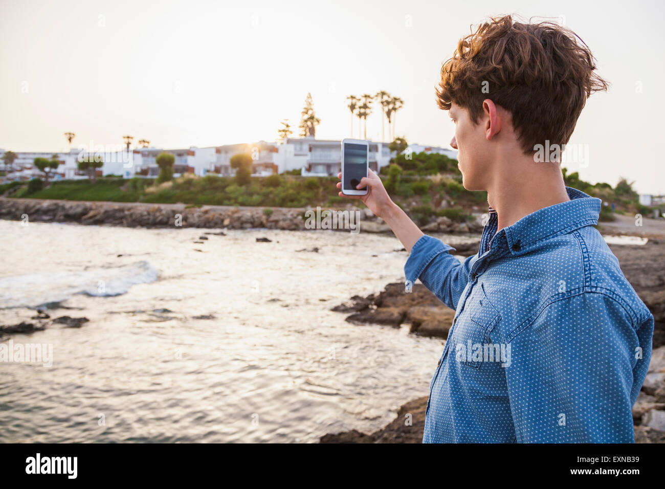 La Grecia, Rodi, giovane fotografare con lo smartphone sul lungomare Foto Stock