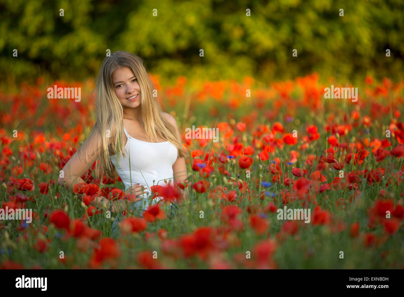 In Germania, in Baviera, il ritratto della ragazza in un campo di semi di papavero Foto Stock