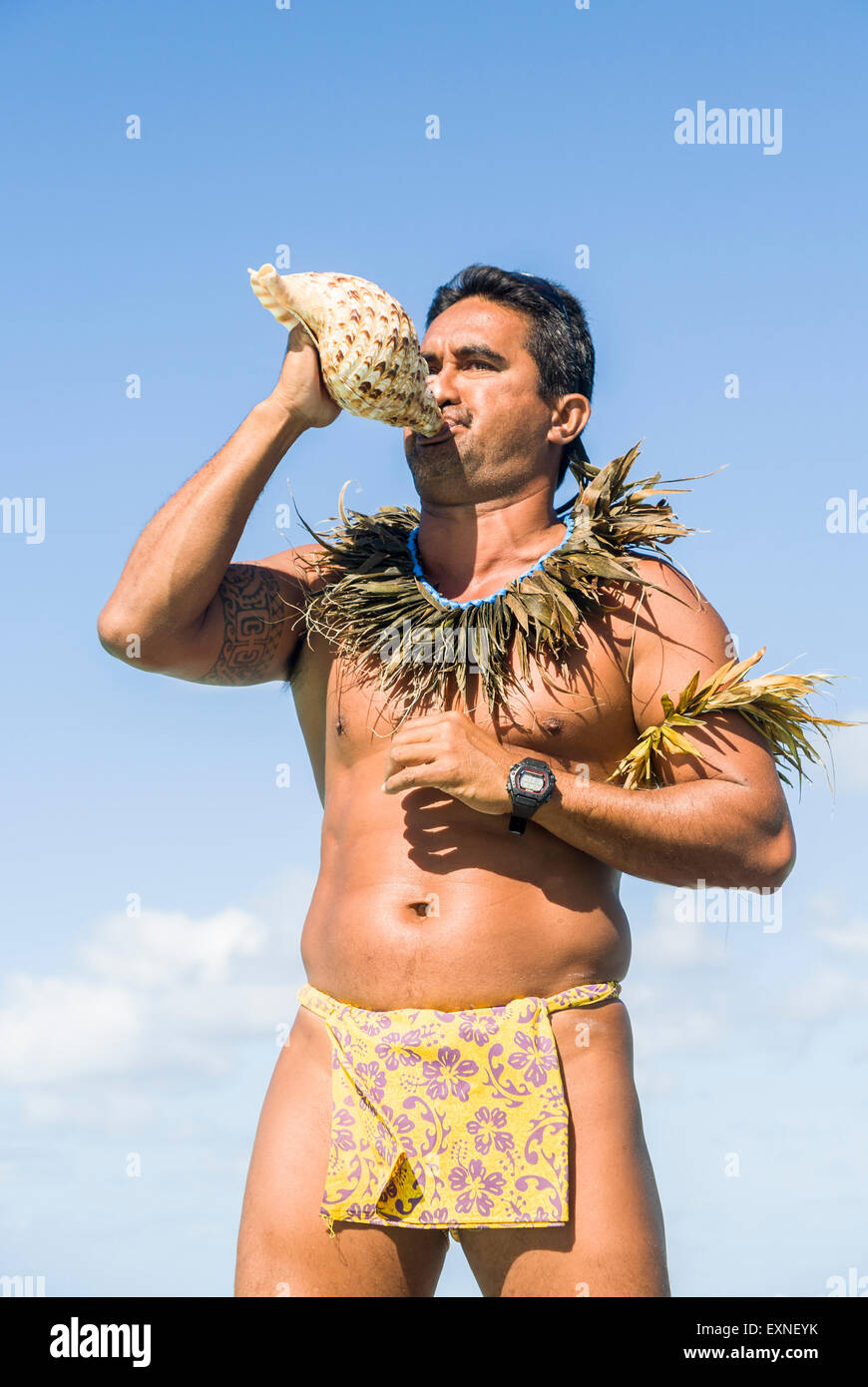 Un locale uomo polinesiano che indossa un perizoma soffiando una conchiglia  corno nella Bora Bora, Polinesia francese Foto stock - Alamy