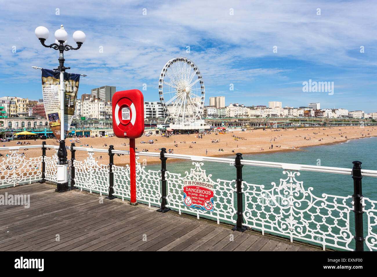 La spiaggia di Brighton costa e la passeggiata sul lungomare di Brighton ruota su una soleggiata giornata estiva con cielo blu, visto dal Palace Pier, East Sussex, Regno Unito Foto Stock