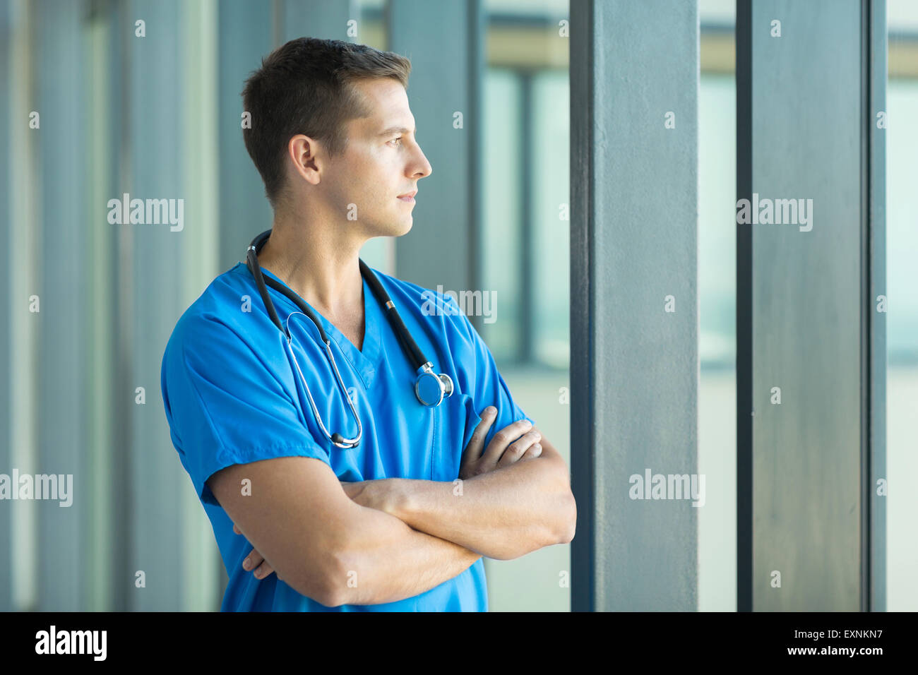 Riflessivo medico guardando attraverso la finestra di ufficio Foto Stock
