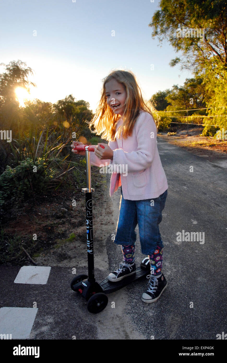 Giovane ragazza ridere e divertirsi sul suo scooter a ALBA Foto Stock