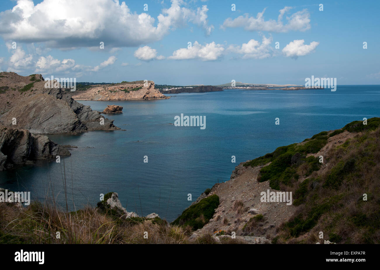 Vista di Addaia in distanza lungo la rocciosa costa nord dell'isola di Minorca spagna Foto Stock