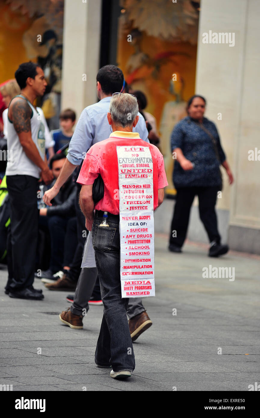 Un uomo nel centro di Dublino a passeggiate per le strade con un messaggio di protesta sul suo retro. Foto Stock