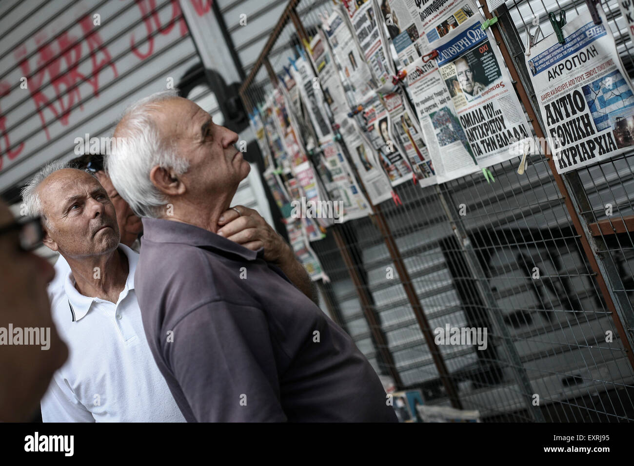 Atene, Grecia. 16 Luglio, 2015. Persone che leggono i titoli di giornali presso un chiosco in Atene, Grecia il 16 luglio 2015. Foto: Baltagiannis Socrates/dpa (zu dpa-Korr "Nach Sparpaket-Votum: Griechen wachen in neuer Realität auf" vom 16.07.2015) Credito: dpa picture alliance/Alamy Live News Foto Stock