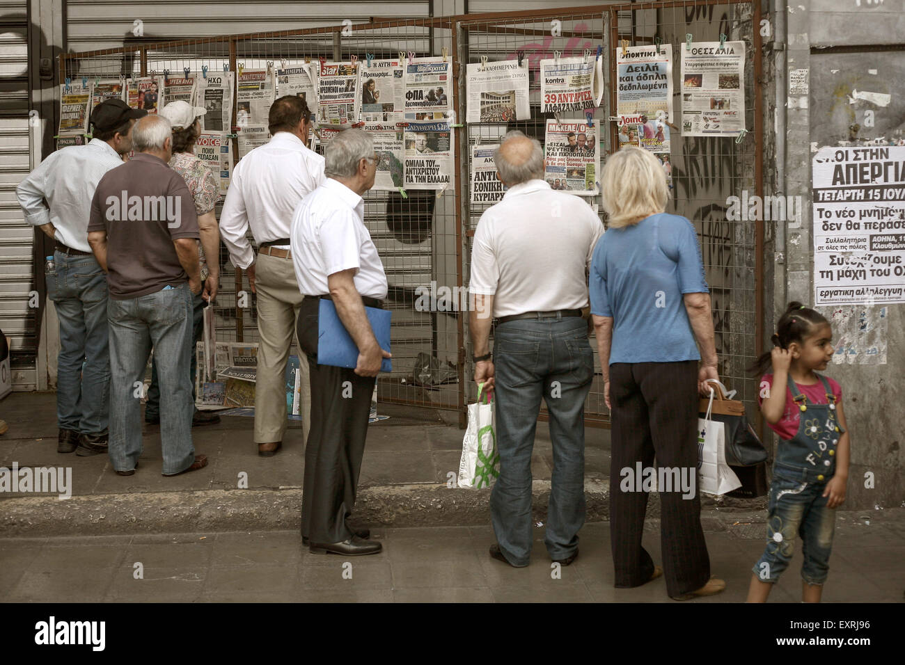 Atene, Grecia. 16 Luglio, 2015. Persone che leggono i titoli di giornali presso un chiosco in Atene, Grecia il 16 luglio 2015. Foto: Baltagiannis Socrates/dpa (zu dpa-Korr "Nach Sparpaket-Votum: Griechen wachen in neuer Realität auf" vom 16.07.2015) Credito: dpa picture alliance/Alamy Live News Foto Stock