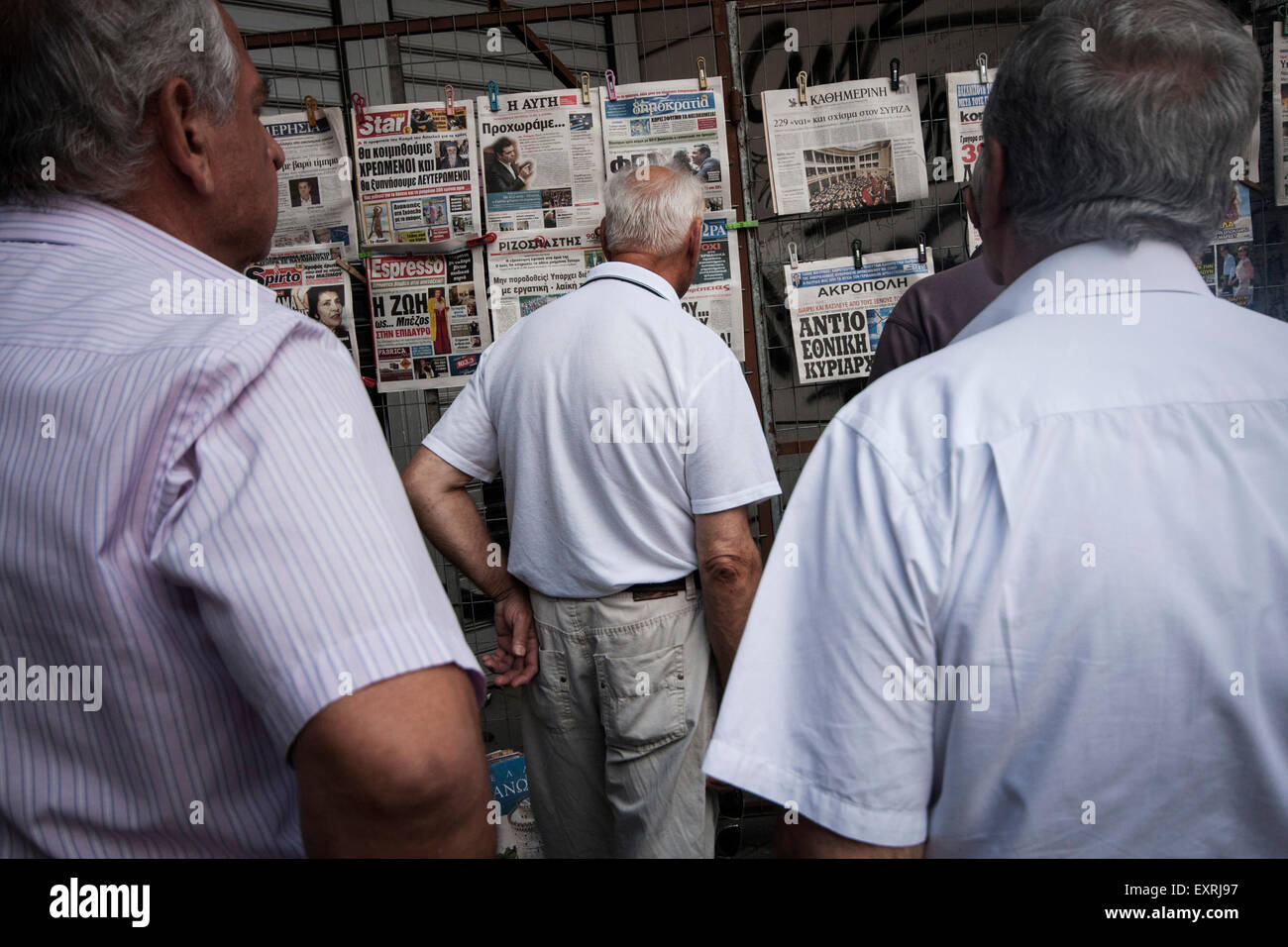 Atene, Grecia. 16 Luglio, 2015. Persone che leggono i titoli di giornali presso un chiosco in Atene, Grecia il 16 luglio 2015. Foto: Baltagiannis Socrates/dpa (zu dpa-Korr "Nach Sparpaket-Votum: Griechen wachen in neuer Realität auf" vom 16.07.2015) Credito: dpa picture alliance/Alamy Live News Foto Stock